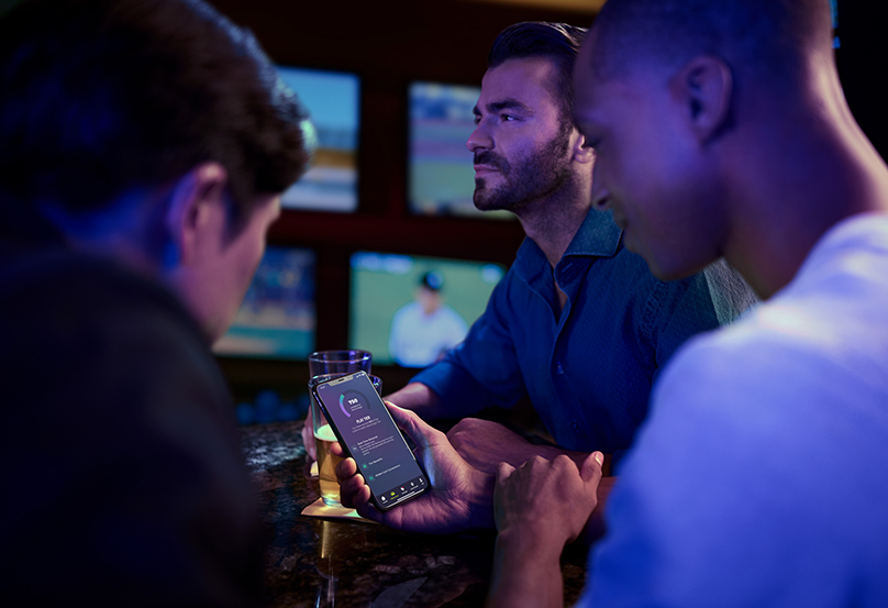 Man using phone to view PENN Play app