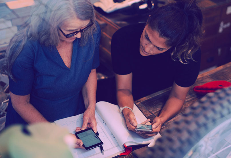 Two women looking at spreadsheet.